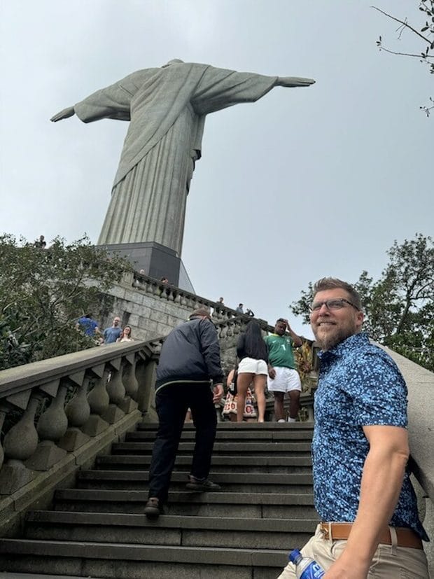 Dr. Jason Gladwell on the steps below the Christ the Redeemer statue in Rio de Janeiro